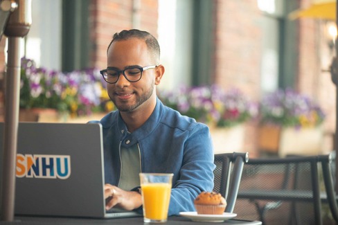 SNHU student sitting at laptop