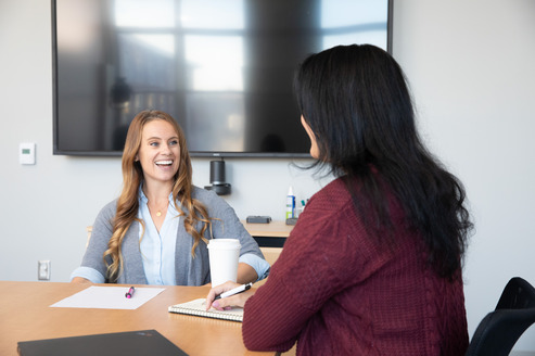 2 people in a meeting laughing